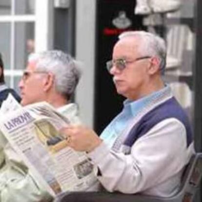 Hombres mayores leen el periódico.