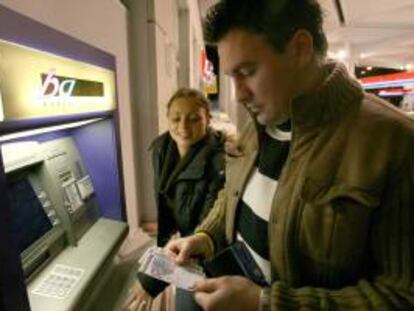 Un hombre observa los billetes de euros que obtiene de un cajero automático. EFE/Archivo