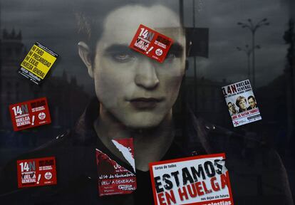 Pegatinas promocionando la huelga general del 14-N tapan el cartel publicitario de una película en la Gran Vía de Madrid.