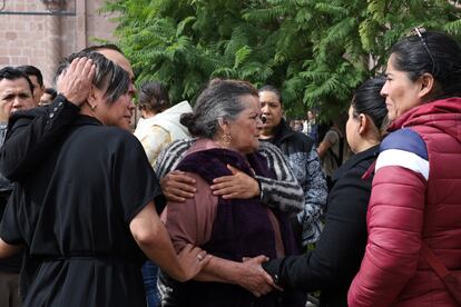 Familiares consuelan a María de la Luz Saucedo, madre de Ociel Baena, afuera de la catedral de Aguascalientes.