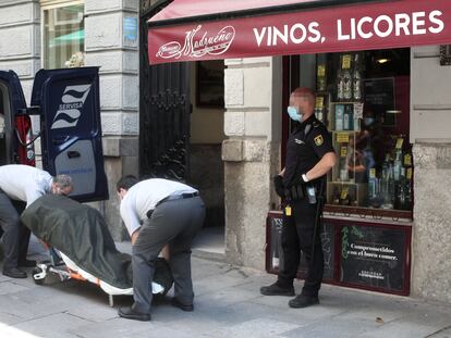 Dos trabajadores de la Funeraria Servisa recogen los cuerpos sin vida del hostal de la calle Postigo de San Martín de Madrid, donde la Policía Nacional ha hallado esta mañana los cadáveres de una mujer de 35 años y su hijo de 5 años.