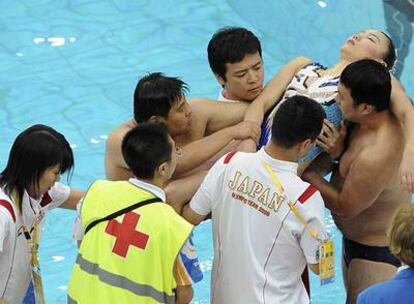 Los técnicos japoneses asisten a la nadadora Kobayashi.