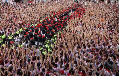 Los mozos agitan sus manos mientras la banda toca durante el chupinazo.