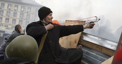 Un manifestante opositor usa un tirachinas durante los enfrentamientos con la policía antidisturbios.