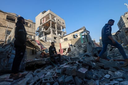 Varias personas inspeccionan los daños causados en varios edificios tras un ataque israelí en Rafah, este sábado.