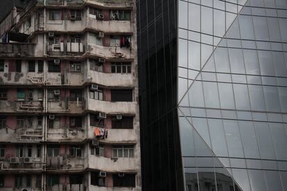 Un antiguo edificio de apartamentos junto a una moderna torre en Hong Kong (China).