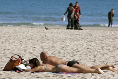 La playa del Postiguet, en Alicante, atrajo a bañistas y personas que se tumbaron a tomar el sol pese al descenso de temperaturas.