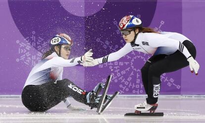 Choi Min-jeong de Corea del Sur ayuda a una compañera a levantarse tras caer a la pista durante la prueba de relevo de los 3.000 metros de velocidad en pista, el 10 de febrero de 2018.