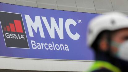 Un operario con mascarilla junto al logo del MWC de Barcelona, cancelado este año por el coronavirus.