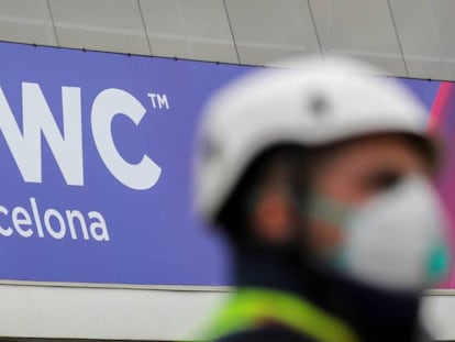 Un operario con mascarilla junto al logo del MWC de Barcelona, cancelado este año por el coronavirus.