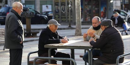 Un grupo de hombres juega a las cartas en una calle de Madrid.