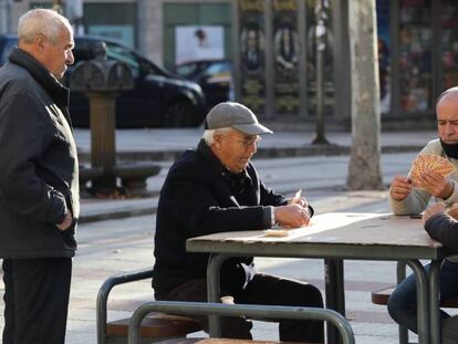 Un grupo de hombres juega a las cartas en una calle de Madrid.
