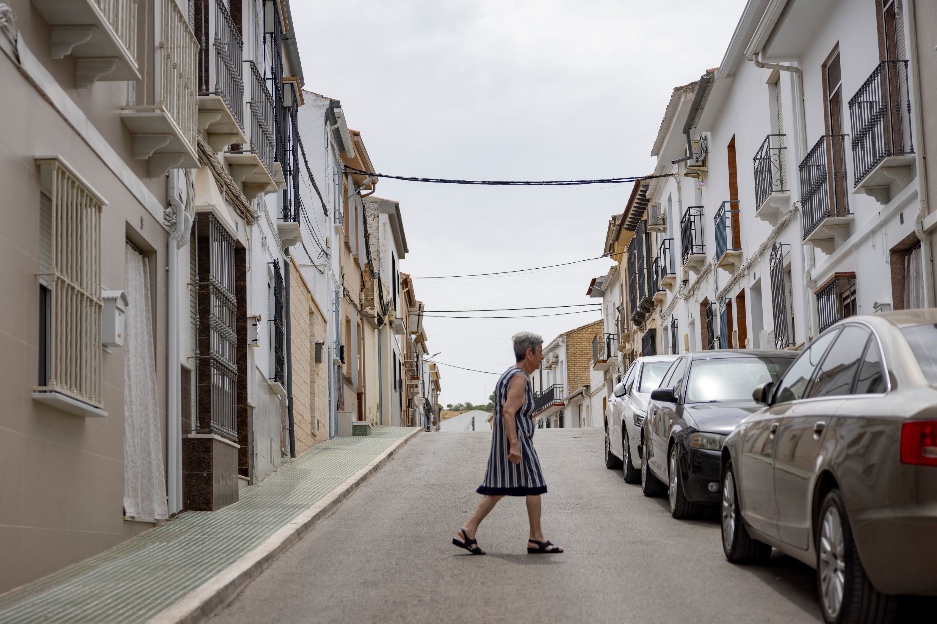 Una vecina atraviesa la calle Tebas de Los Corrales, donde vive la suegra de Santos Cerdán.