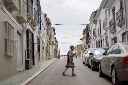 Una vecina atraviesa la calle Tebas de Los Corrales, donde vive la suegra de Santos Cerdán.