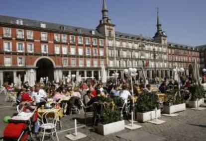 Turistas aprovechan el buen tiempo de la capital para disfrutar del aperitivo y del sol en las terrazas instaladas en la Plaza Mayor. EFE/Archivo