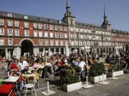 Turistas aprovechan el buen tiempo de la capital para disfrutar del aperitivo y del sol en las terrazas instaladas en la Plaza Mayor. EFE/Archivo