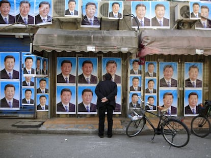 Transeunte observa cartazes com a imagem do presidente Xi Jinping, em Xangai.