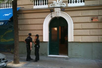 Dos policías frente a la casa de la calle de Gaztambide donde los servicios de emergencias han encotrado el cadáver de la mujer rodeado de sangre seca.