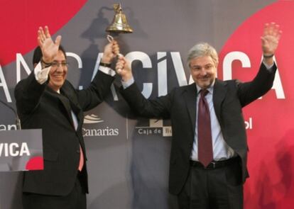 Los copresidentes de Banca Cívica, Enrique Goñi (derecha) y Antonio Pulido (izquierda), tras el tradicional toque de campana.