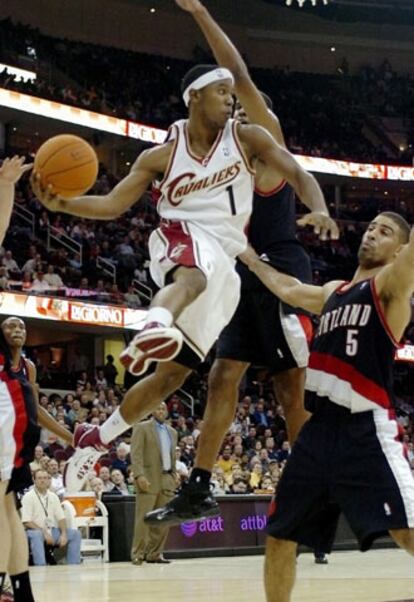 Daniel Gibson, de los Cavaliers de Cleveland, pasa el balón en presencia del jugador de los Trail Blazers de Portland Ime Udoka.