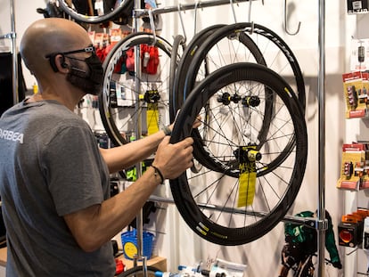 Un trabajador coloca una rueda en una tienda de bicicletas en Málaga.