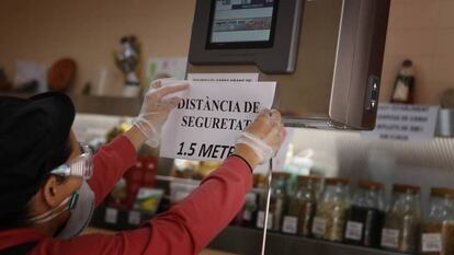 El encargado de un negocio de alimentación en Terrassa (Cataluña) coloca un cartel de advertencia en el mostrador el pasado lunes.