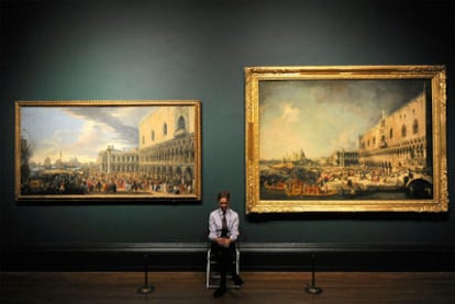Una guarda de seguridad de la National Gallery, entre un paisaje de Luca Carlevarijs (izquierda) y otro de Canaletto.