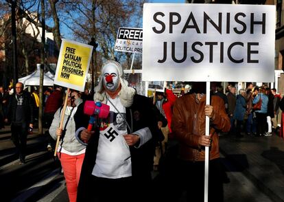 Alguns dos manifestantes usavam máscara de palhaço e portavam cartazes em inglês que pediam liberdade para os presos.