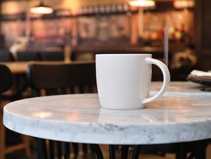 Una taza de café en la mesa de una cafetería.