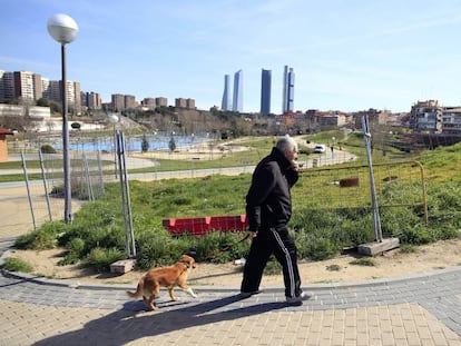 Un hombre pasea con su perro por el vallado parque Agust&iacute;n Rodr&iacute;guez Sahag&uacute;n de Madrid. 