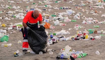 Un operario del servicio municipal de limpieza de Málaga recogía basura en la playa de La Malagueta tras la celebración de la pasada noche de san Juan.