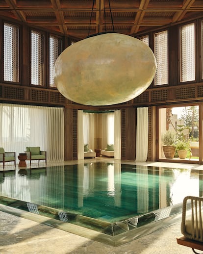 Piscina de mármol verde con una luna gigante que se ilumina de noche. 