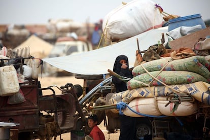 A displaced Syrian woman, who fled the countryside surrounding the Islamic State (IS) group stronghold of Raqa, arrives at a temporary camp in the village of Ain Issa on April 28, 2017. / AFP PHOTO / DELIL SOULEIMAN