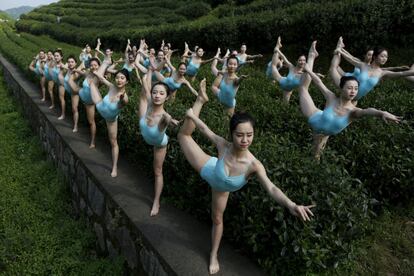 Un grupo de niñas realiza yoga en una plantación de té d Cina como parte del programa de televisión.