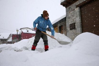 Un hombre despeja de nieve la entrada a una vivienda en la localidad de Sotres, en el concejo de Cabrales (Asturias). 