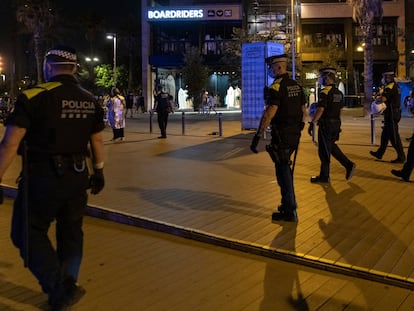 Agentes de la Guardia Urbana forman una línea en las inmediaciones de la playa de la Barceloneta para hacer efectivo el toque de queda, en una imagen de archivo.