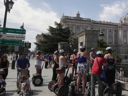 Grupo de turistas en los exteriores del Palacio Real de Madrid.