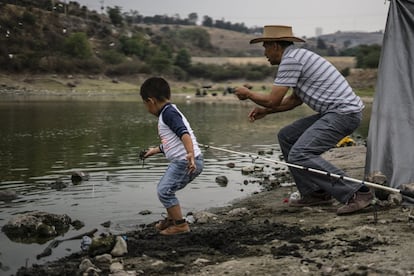 Un hombre pesca en la orilla de la presa Madín mientras su hijo juega con la tierra. Las familias vecinas de Naucalpan pasan las tardes descansando o pescando en el lugar. Muchos temen empezar a sufrir problemas de abastecimiento si se llevan parte del agua de la presa a Ciudad de México.