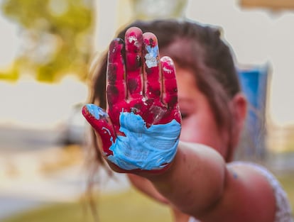 Una niña muestra su mano pintada.