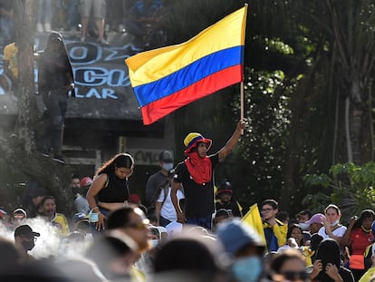 Un manifestante sostiene la bandera de Colombia durante una protesta contra el gobierno de Iván Duque, en Cali