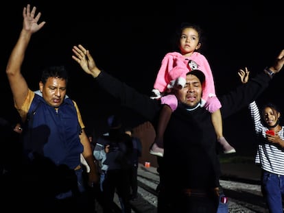 Un grupo de migrantes poco después de cruzar un hueco en la barrera fronteriza entre Estados Unidos y México, mientras esperan que la Patrulla Fronteriza los procese, el 23 de mayo de 2022 en Yuma, Arizona.