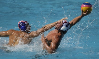 Lucca Cupido (d) d'Estats Units tracta de passar la pilota sota la pressió del croat Luka Bukic, en una ronda preliminar de waterpolo.