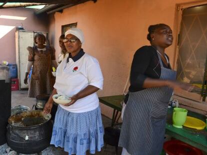 En el centro, de blanco, Seipati Mmekwa la mujer del obispo que ha montado el comedor social.