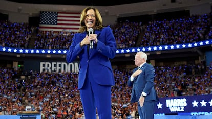 Los candidatos demócratas a presidenta de EE UU, Kamala Harris (en primer plano) y a vicepresidente, Tim Walz, agradecen los aplausos a los asistentes a la convención demócrata.