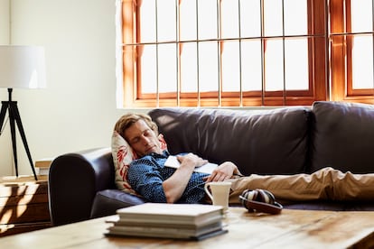 Mid adult man with digital tablet sleeping on sofa