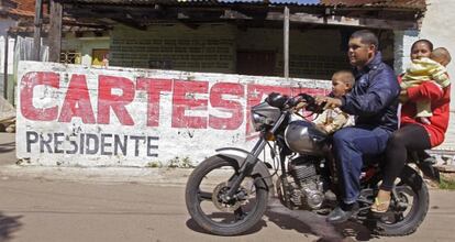 Una familia pasa ante una pintada a favor de Horacio Cartes.