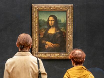 Dos personas observan la Mona Lisa de Leonardo Da Vinci en la galería del Louvre de París, Francia, en 2021.