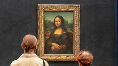 Dos personas observan la Mona Lisa de Leonardo Da Vinci en la galería del Louvre de París, Francia, en 2021.