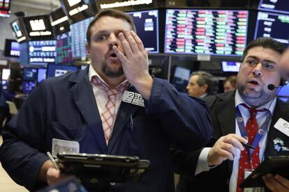 Dos trabajadores de Wall Street reaccionan mientras observan los resultados de La Bolsa, este martes.