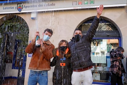 La encargada de la administración de lotería, Mónica (en el centro), uno de los agraciados, Juanjo (a la derecha) y algunos amigos celebran el primer premio en la administración número 1 de Sallent (Barcelona).